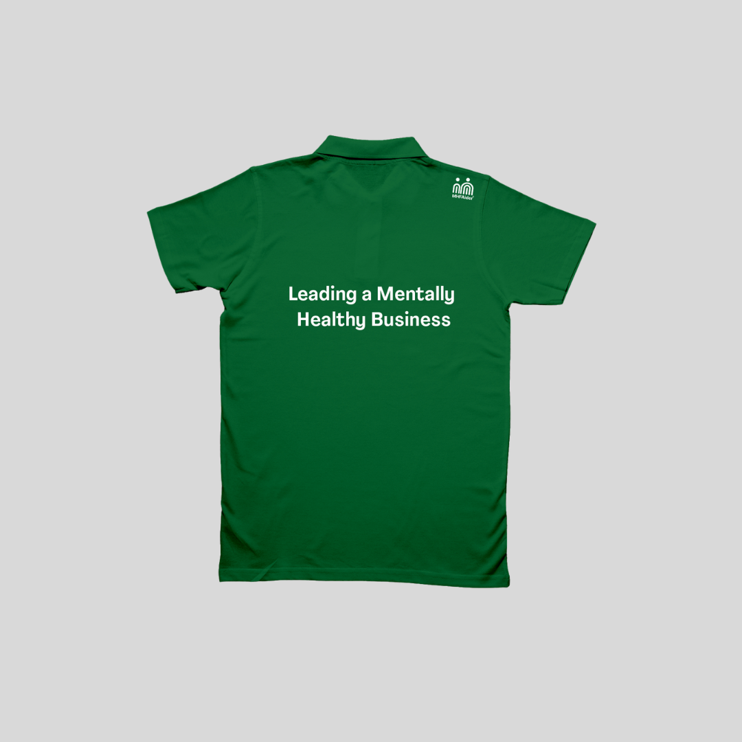 A green short-sleeve polo shirt shown from the back, featuring the white printed text 'Leading a Mentally Healthy Team' across the center and a small white logo on the upper right shoulder, displayed against a solid gray background.
